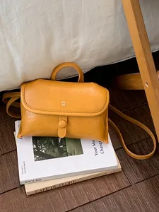 Kleine vintage gele lederen crossbody handtas met XX-borduurwerk op tijdschrift
