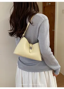 Squisita borsa sottobraccio color crema da donna con un'atmosfera retrò minimalista.