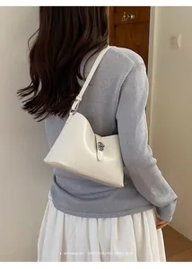 Elegante borsa sottobraccio minimalista bianco crema mostrata su modella per l'ufficio