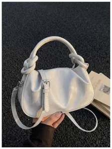 Vue macro détaillée du sac à main perle blanc avec poignée nouée et impression de marque