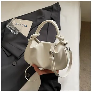 Détail rapproché du sac à main blanc cassé avec poignées nouées et bandoulière