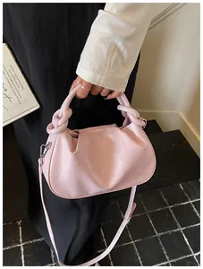 Sac à main rose style dumpling avec poignée nouée unique et texture cuir élégante