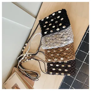 Cuatro bolsos de mano tejidos para móvil con conchas en tonos tierra neutros