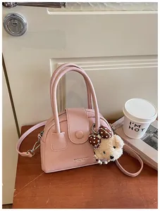 Detailopname van de stijlvolle roze getextureerde lederen pillow bag met beerhanger