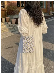Vista trasera detallada de un bolso de hombro tejido de verano en vestido blanco