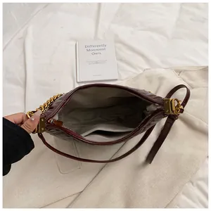 Interior view of burgundy quilted shoulder bag showing gray lining and inner pocket