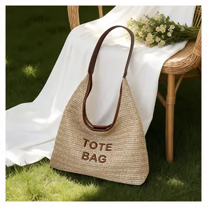Handmade woven straw tote bag with brown shoulder straps for summer beach vacations
