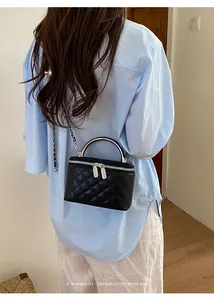 Detailed back view of a chic black quilted vanity box bag with silver chain and handle.