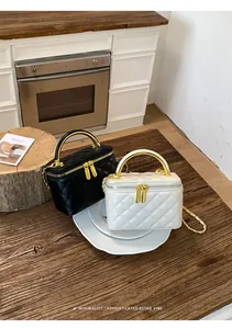 Elegant quilted box bags in black and white with gold chain straps and top handles