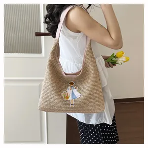 Handmade woven straw tote bag with cute embroidery for summer beach vacation.