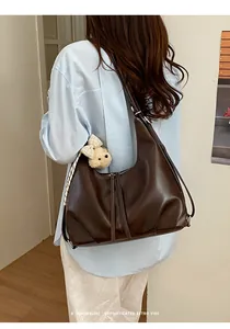 Vista posteriore ravvicinata di una donna che indossa una grande borsa in pelle marrone