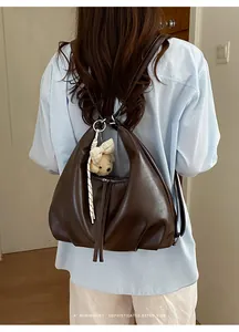 Modella che indossa uno zaino minimalista in pelle marrone scuro vista da dietro