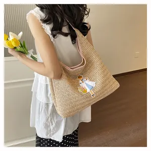Detail view of woven straw tote bag featuring a cute embroidered girl patch design