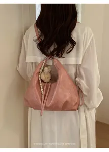 Vista posteriore di una modella con un elegante zaino hobo convertibile in pelle rosa