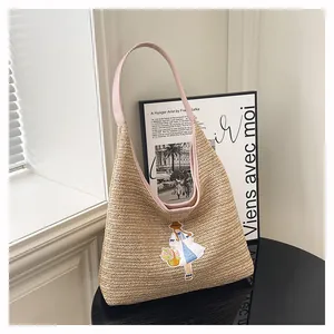 Close-up of handmade straw tote bag with cute embroidery detail and pink strap