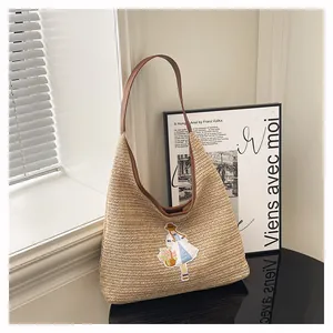 Detailed view of woven straw tote bag featuring a cute cartoon girl embroidery patch.