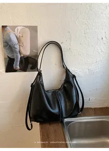 Primo piano di una borsa minimalista in pelle nera in un ambiente retrò sofisticato.