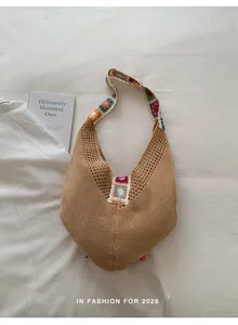 Detalle de cerca del bolso de punto calado con motivos florales de ganchillo de colores
