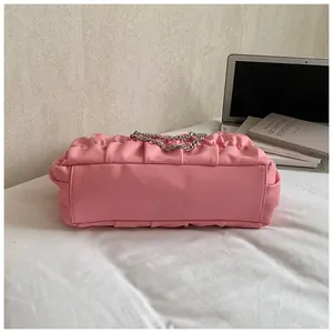 Bottom view of pink pleated tote bag with silver chain strap and ruched texture