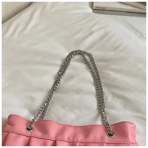 Detailed close-up showing the silver chain strap and pink pleated texture of this tote bag