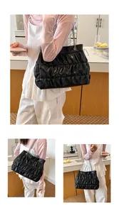Lifestyle shots of a black pleated large-capacity tote bag with silver chain straps