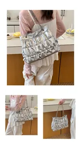 Detail view of large silver pleated tote bag with chain strap for casual styling.