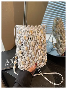Detalle de bolso para móvil de macramé blanco tejido a mano con cuentas de ámbar