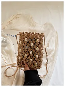 Detalle de bolso de macramé para móvil hecho a mano con cuentas de concha para vacaciones playa.