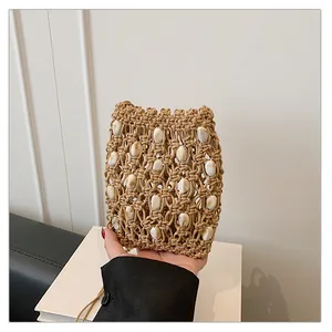 Vista detallada del bolso de mano tejido para móvil con adornos de conchas de mar