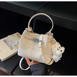 Elegante cremeweiße Beuteltasche mit strukturierter Oberfläche und süßem Welpenanhänger
