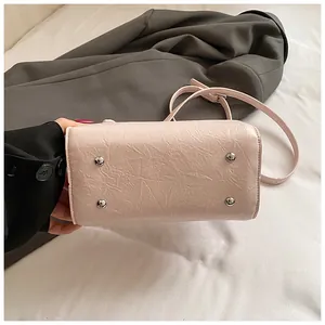 Bottom view of pink vintage Boston bag showing metal feet and textured leather
