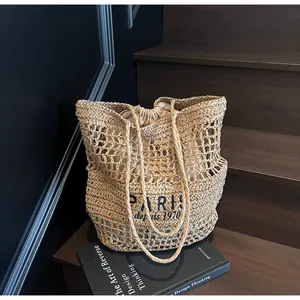 Détail d'un sac cabas en paille fait main avec broderie "PARIS" et doublure interne.
