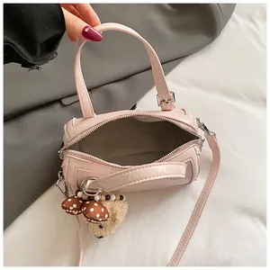 Detailed top-down view of the pink mini Boston bag interior with a cute plush charm