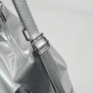 Detailed view of the metallic silver finish and adjustable strap buckle on a women's tote bag