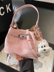 Stilvolle rosa strukturierte Damen-Eimertasche mit flauschigem Hundeanhänger für den Frühling