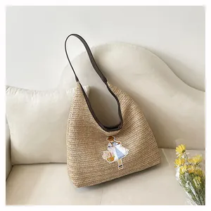 Close-up detail of handmade straw woven tote bag with a cute embroidered girl character
