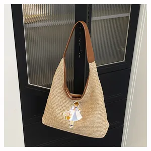 Handmade large woven straw tote bag with girl embroidery detail for summer beach vacations