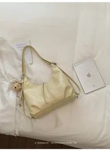 Vista ravvicinata di una borsa a tracolla crema versatile con dettagli retrò minimalisti