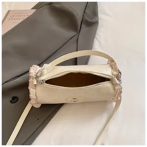 Detailed top view of cream barrel bag with pink polka dots, ruffle edges and bear patch