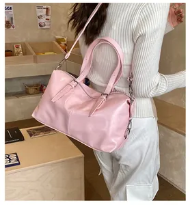 Gros plan d'un sac oreiller en cuir rose élégant porté en bandoulière dans un café