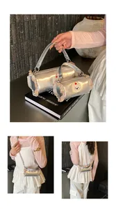 Detail view of silver metallic cylinder crossbody bag with pink ruffles and bear patch