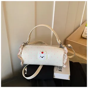 Cream barrel handbag with pink polka dots, cute cartoon patch, and ruffled side details.