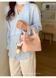 Elegant pink textured bucket bag with cute bear charm held by a model in a lifestyle setting