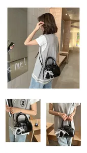 Elegant black top-handle handbag with lace bow detail and pearl charm for ladies