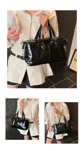 Détail d'un sac à main noir brillant rétro porté en bandoulière pour femme