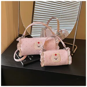 Macro view of stylish pink cylindrical handbags featuring polka dots and lace ruffles