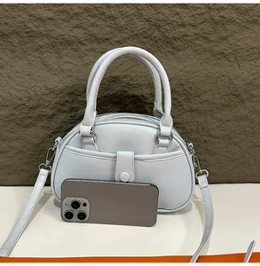 Elegant light blue luxury handbag size comparison with a smartphone detail view