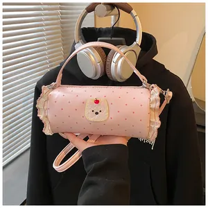 Close-up of pink polka dot cylinder handbag with cute bear detail and ruffle edges