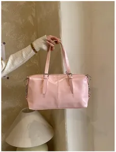 Gros plan d'un élégant sac à main rétro rose en forme d'oreiller tenu par la main d'un modèle