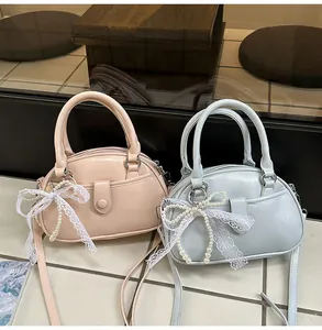 Two elegant small luxury handbags in pink and light blue featuring a pearl lace bow detail
